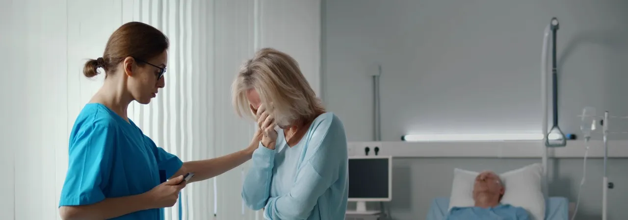 Nurse is at bedside of a patient delivering bad news